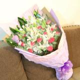 鲜花:2枝粉香水百合，9枝红玫瑰，洋桔梗1枝或白玫瑰、米兰点缀；卷边纸外围，粉色纱网大蝴蝶结，圆形包装