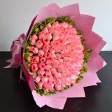 99朵粉玫瑰:6枝黄色百合、配材。高级绿色皱纸包装圆形花束（此花需提前预定）。